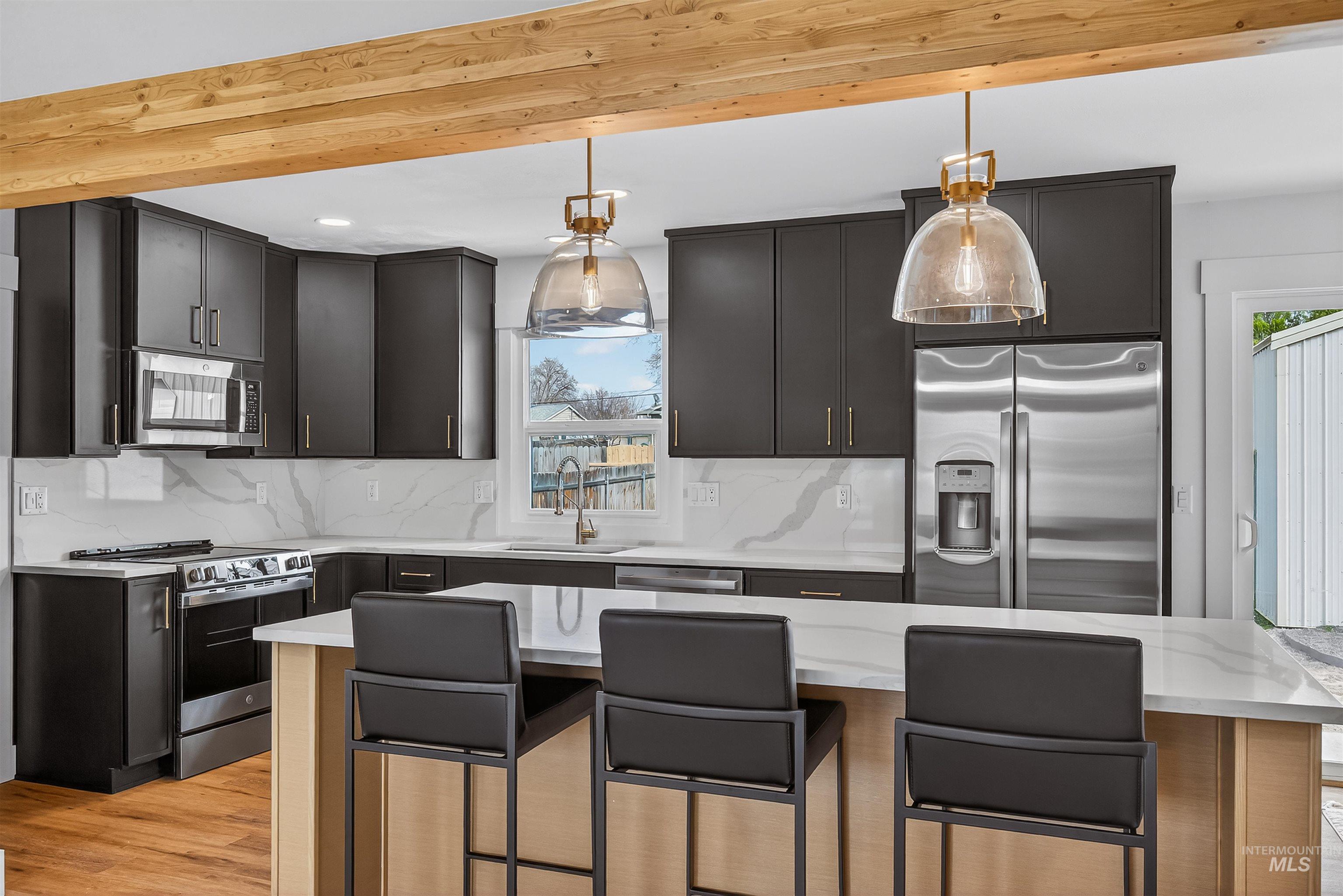 3513 8th Street Lewiston, ID 83501 - Photo 7 of 43 Kitchen featuring a kitchen island, stainless steel appliances, a kitchen breakfast bar, and pendant lighting