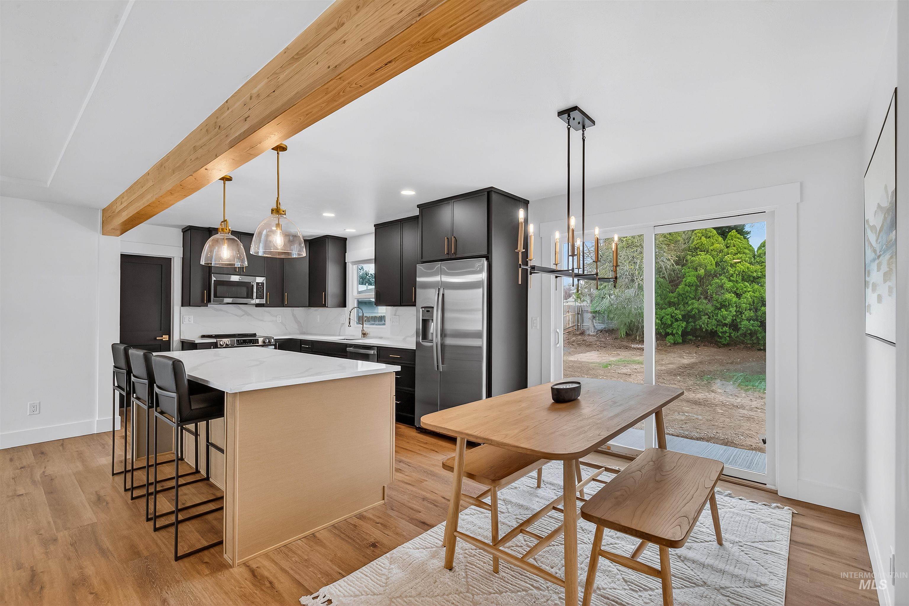 3513 8th Street Lewiston, ID 83501 - Photo 9 of 43 Kitchen with a kitchen island, stainless steel appliances, a kitchen breakfast bar, hanging lights, and light wood-type flooring