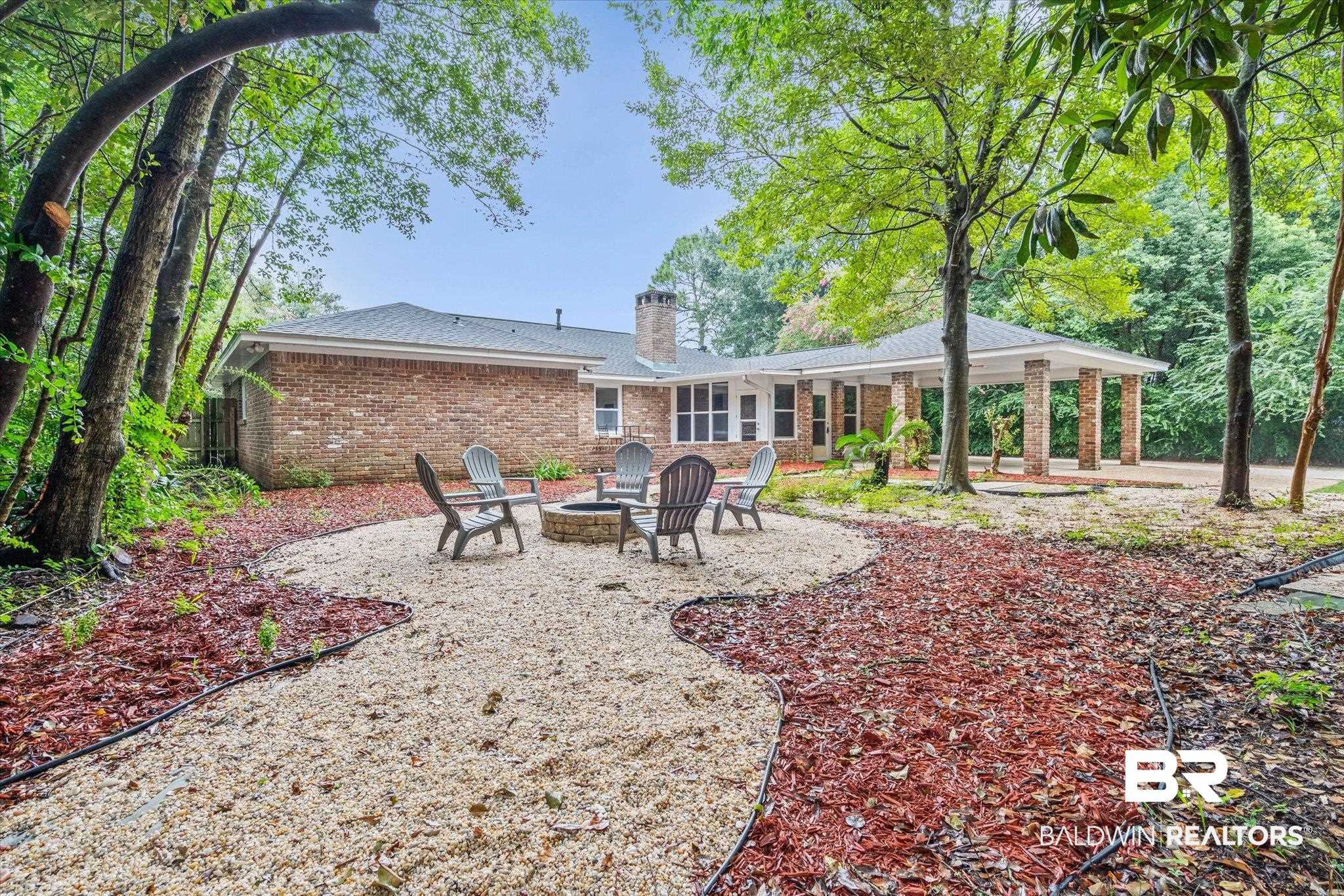 3655 Claridge Road South Mobile, AL 36608 - Photo 29 of 32 Back of house featuring an outdoor fire pit, a patio area, brick siding, and a chimney