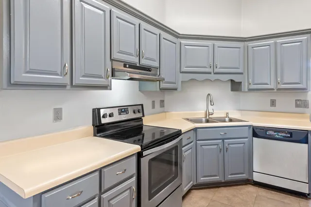 a kitchen with white cabinets and white appliances