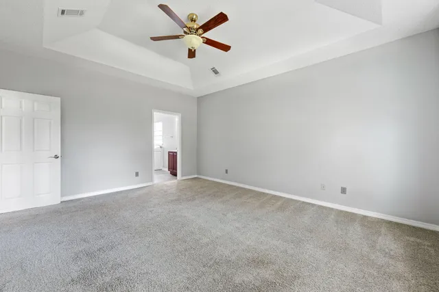 an empty room with a window and a fan