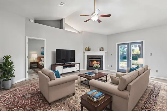 a living room with furniture a flat screen tv and a fireplace