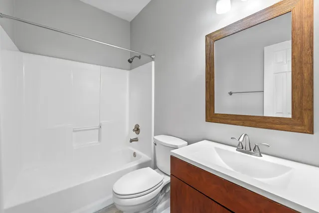 a bathroom with a sink toilet vanity and shower