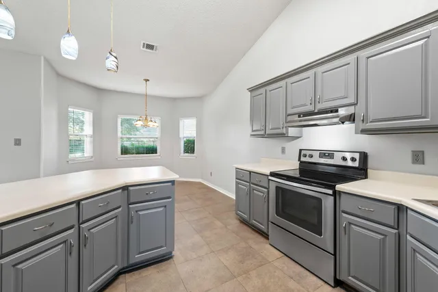 a kitchen with stainless steel appliances granite countertop a sink and a stove