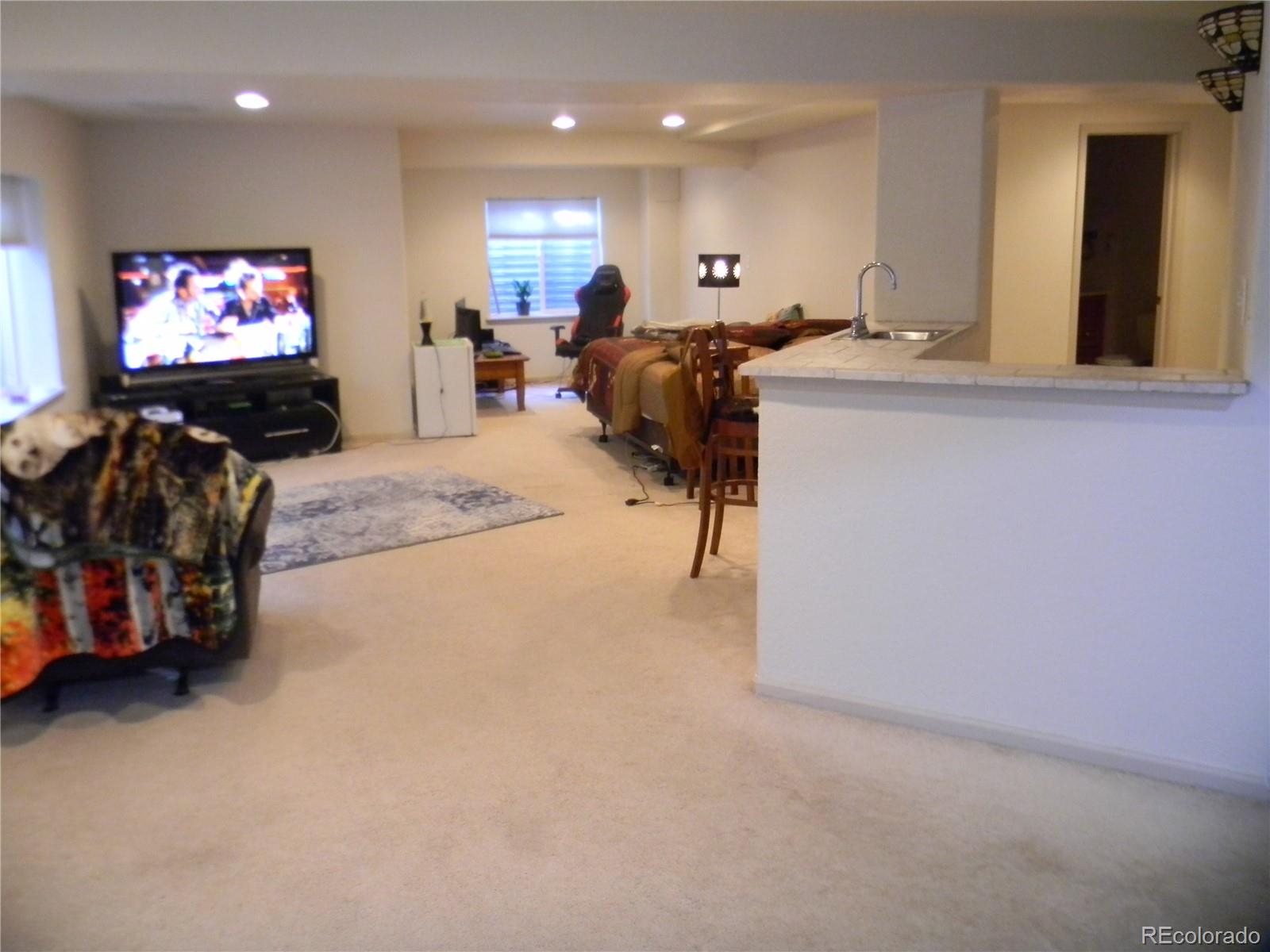 4092 Starflower Road Castle Rock, CO 80109 - Photo 23 of 28 a living room with furniture and a flat screen tv
