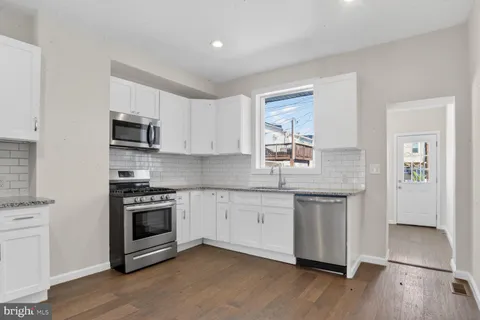 a kitchen with stainless steel appliances granite countertop a stove a sink and a microwave
