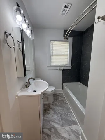 a bathroom with a sink a toilet and bathtub