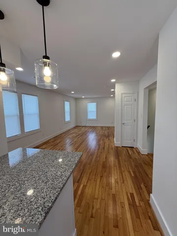 a view of a room with wooden floor and a ceiling fan