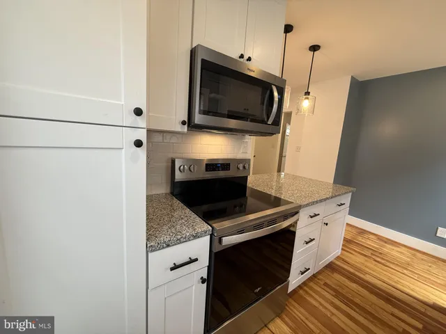a kitchen with stainless steel appliances a stove microwave and refrigerator