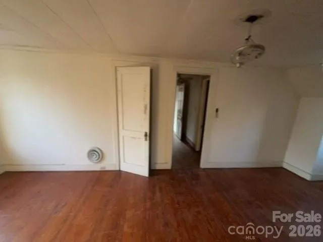 an empty room with wooden floor and closet