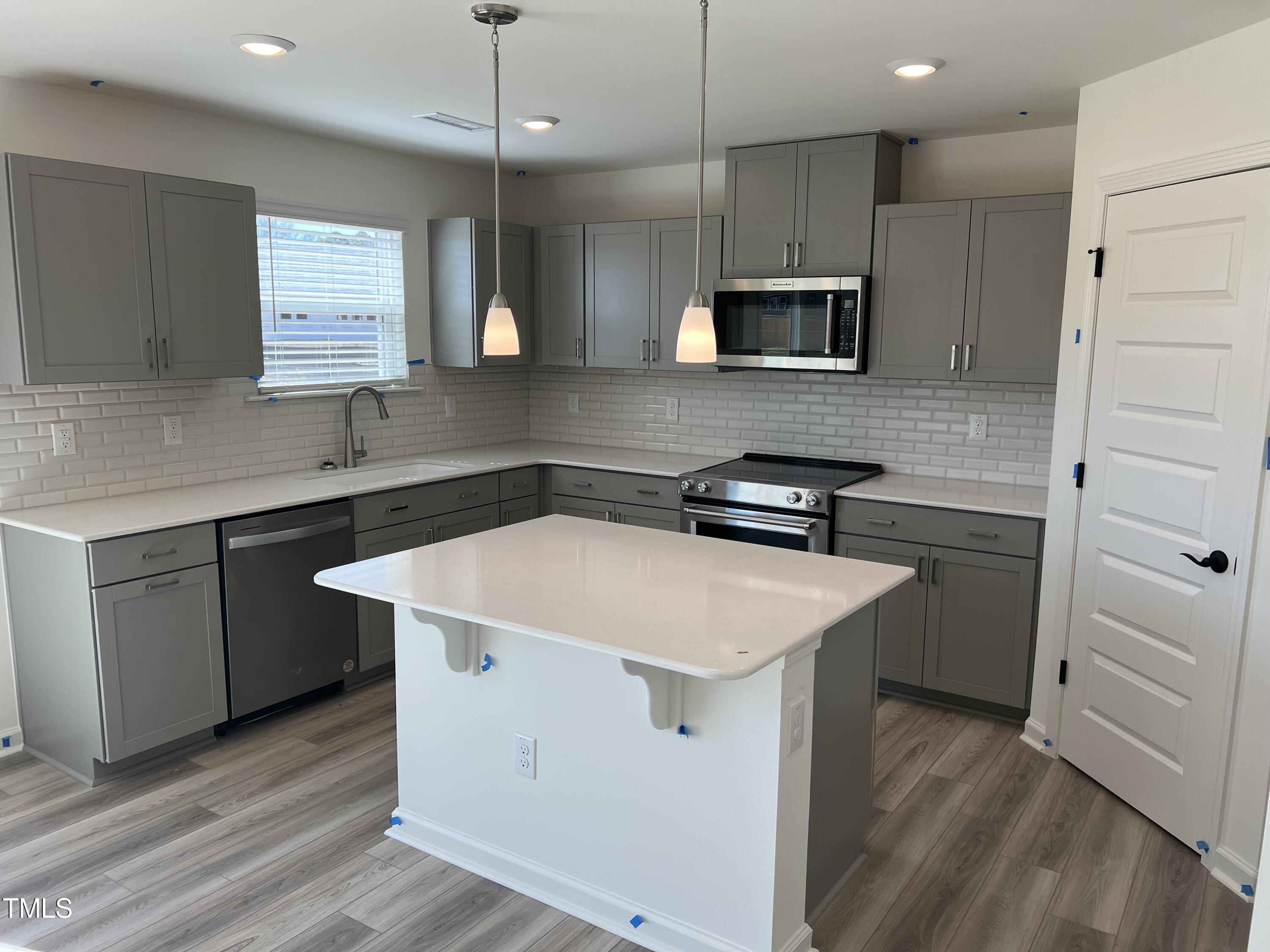 7633 Redwood Rdg Way Willow Spring, NC 27592 - Photo 3 of 10 a kitchen with a sink a microwave a stove and refrigerator