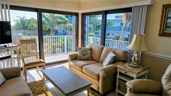 a living room with furniture and a floor to ceiling window
