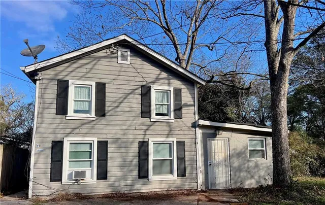 a front view of a house with mountain view and trees