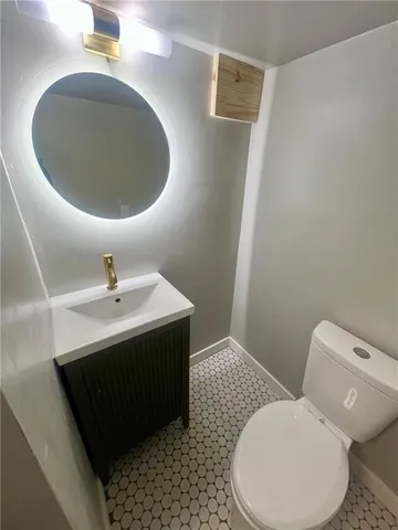 a bathroom with a toilet sink and mirror