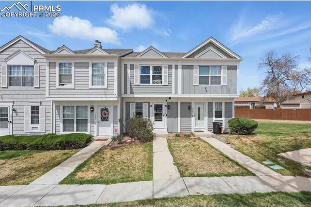 a front view of a house with a yard and potted plants
