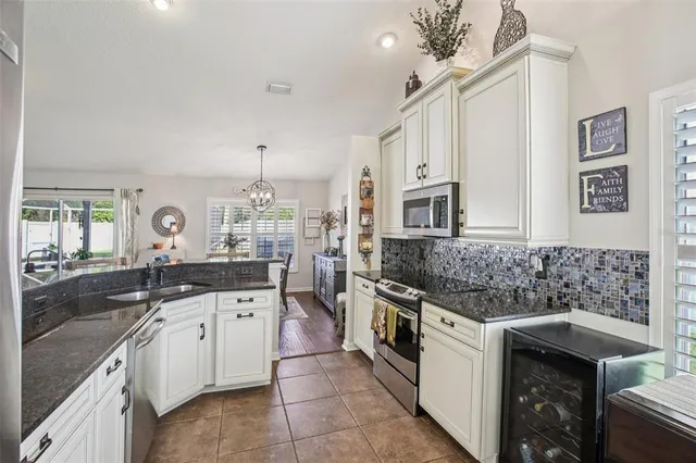 a kitchen with stainless steel appliances granite countertop a sink stove and cabinets