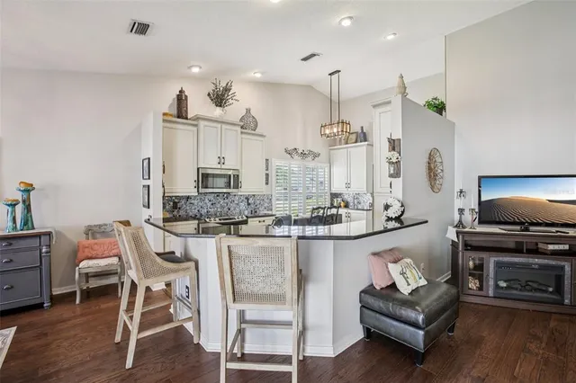 a kitchen with stainless steel appliances kitchen island granite countertop a stove a sink and a refrigerator