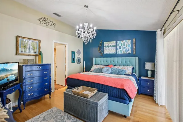 a bedroom with a bed and a chandelier