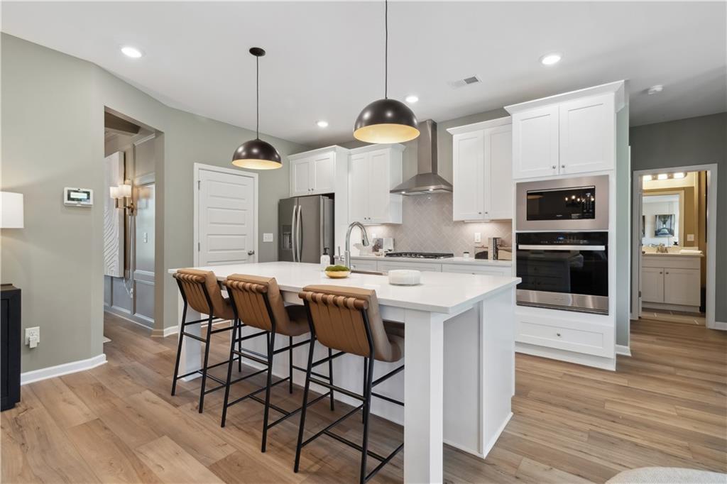 412 Hartsfield Road McDonough, GA 30252 - Photo 18 of 43 a kitchen with a table chairs refrigerator and microwave
