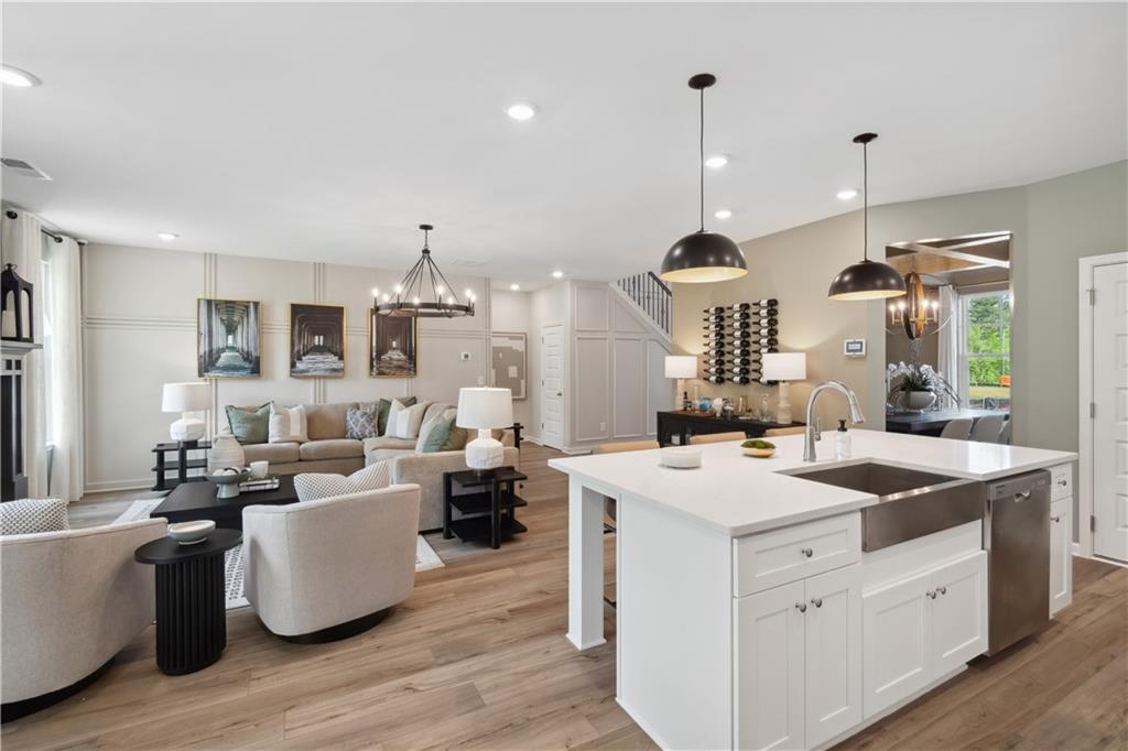 412 Hartsfield Road McDonough, GA 30252 - Photo 24 of 43 a large kitchen with kitchen island stainless steel appliances a stove center island and living room view