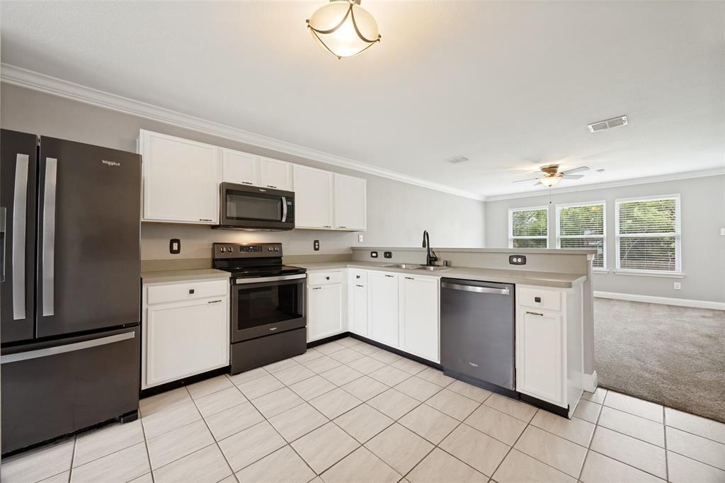1601 Elm Street Anna, TX 75409 - Photo 7 of 25 a kitchen with granite countertop white cabinets and stainless steel appliances
