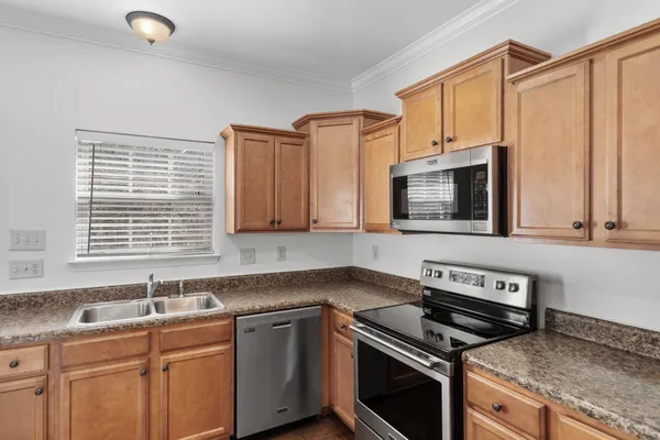 a kitchen with stainless steel appliances a stove sink and microwave