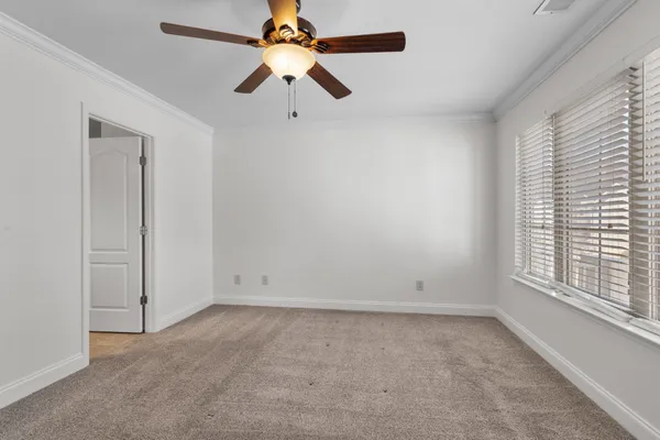 an empty room with a window and a fan