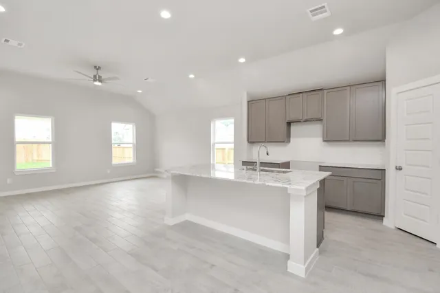 a kitchen with stainless steel appliances granite countertop a sink cabinets and wooden floor