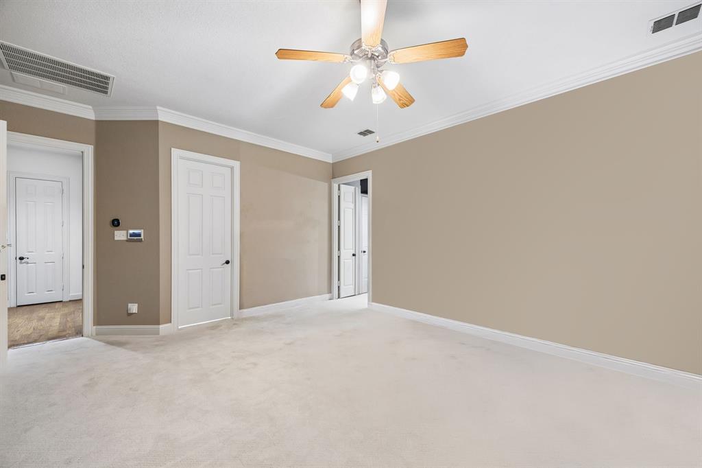5802 Corinth Chapel Road Parker, TX 75002 - Photo 15 of 40 The primary suite has an expanded walk-in closet, en suite bathroom, carpet, crown moulding and ceiling fan.