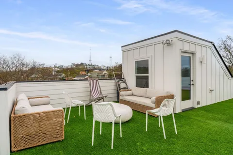 a balcony with furniture and a garden