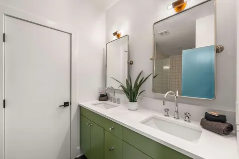 a bathroom with a double vanity sink and a mirror