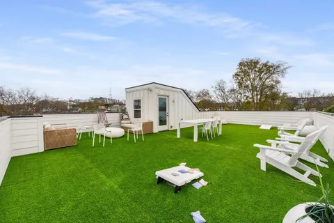 a view of a white house with a yard porch and sitting area