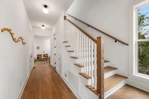 a view of a hallway with wooden floor and staircase