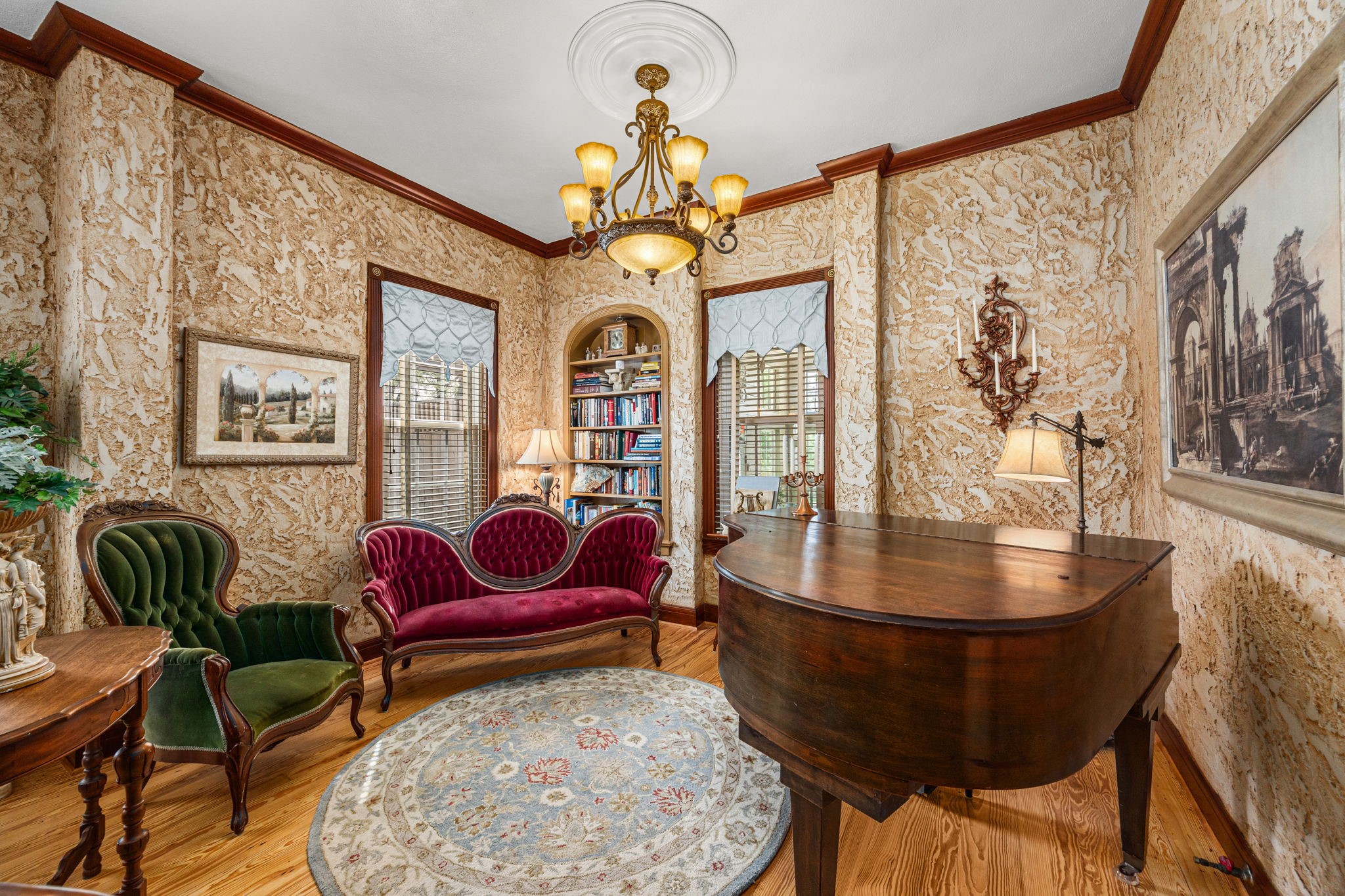 801 West Main Street Brenham, TX 77833 - Photo 13 of 50 Tucked just beyond the formal living room, this charming sitting area offers the perfect space for conversation, reading, or music. An arched built in bookcase, elegant lighting, rich textured walls, and beautiful hardwood floors continue the home's timeless style and historic appeal.