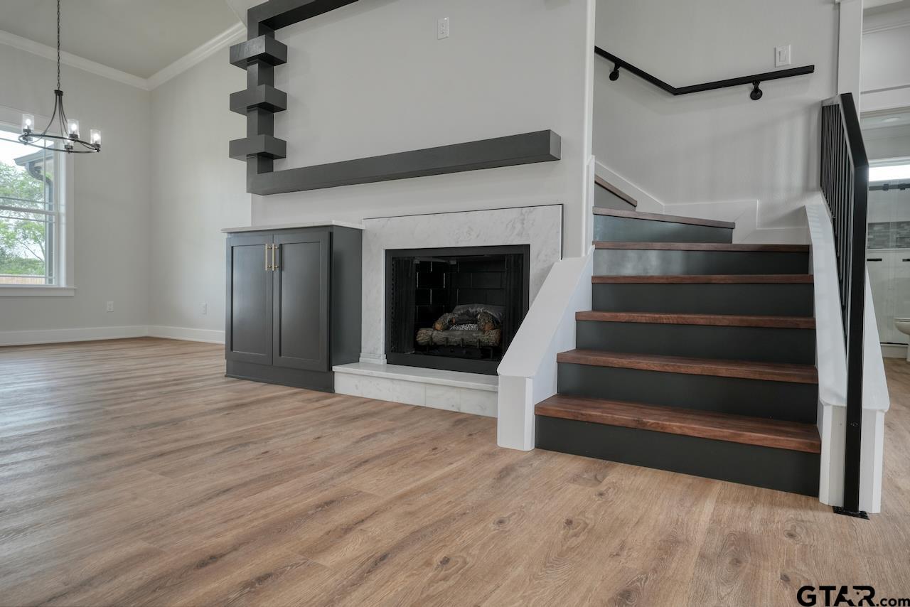 19383 Ridge Point Circle Lindale, TX 75771 - Photo 7 of 48 a view of staircase with a fireplace and wooden floor