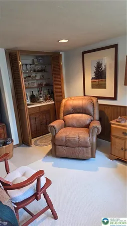 a living room with furniture a rug and kitchen view