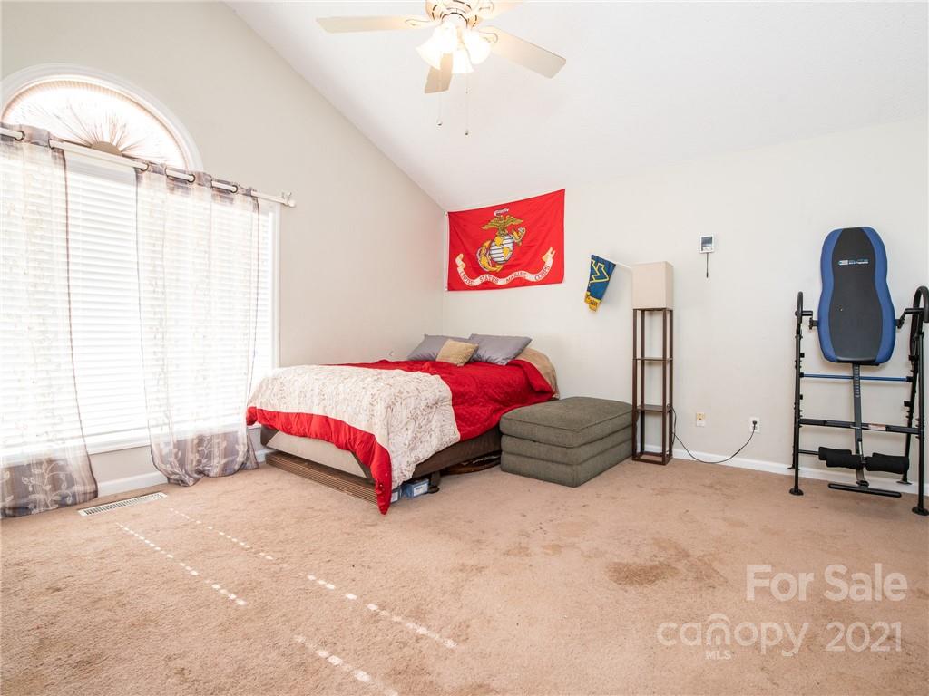 128 Altan Ridge Drive Monroe, NC 28112 - Photo 20 of 42 a bedroom with a bed and a chandelier