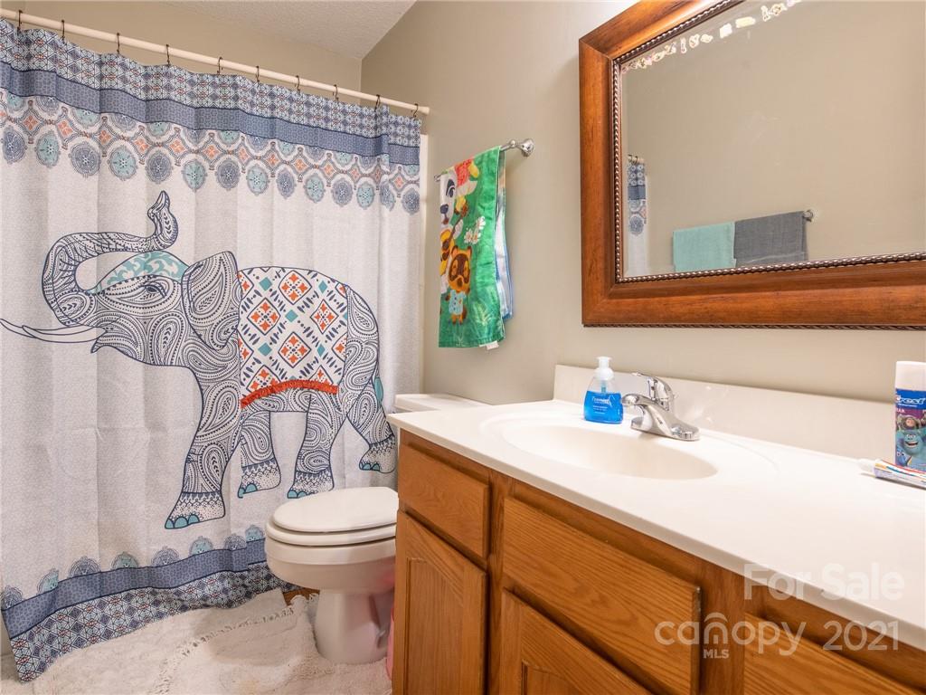 128 Altan Ridge Drive Monroe, NC 28112 - Photo 27 of 42 a bathroom with a sink a toilet and a mirror