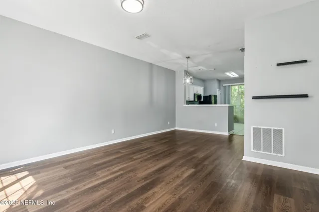 a view of a kitchen with wooden floor and a ceiling fan