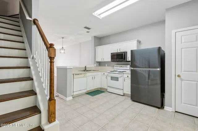 a kitchen with granite countertop cabinets stainless steel appliances and a sink