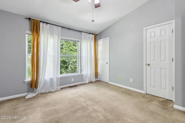 an empty room with closet and a chandelier fan