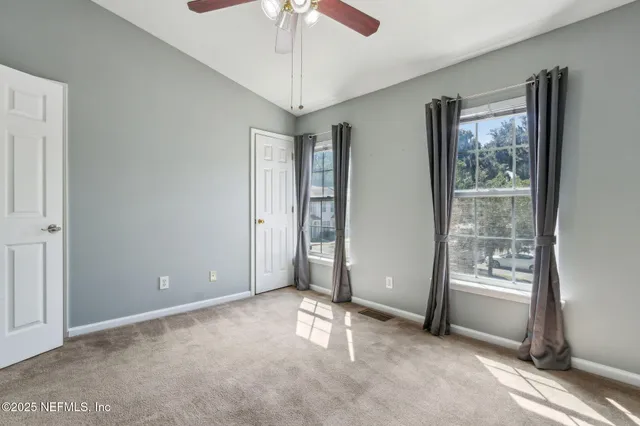 an empty room with closet and a chandelier fan