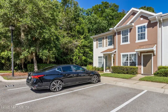 a car parked in front of a white house