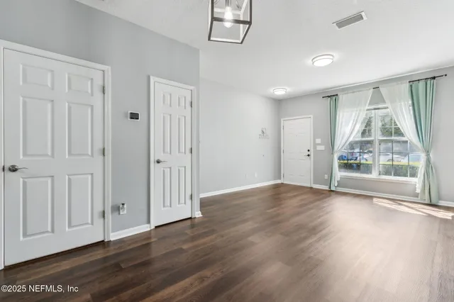 an empty room with wooden floor and window
