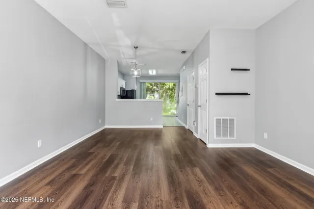 a view of a kitchen with wooden floor and a window