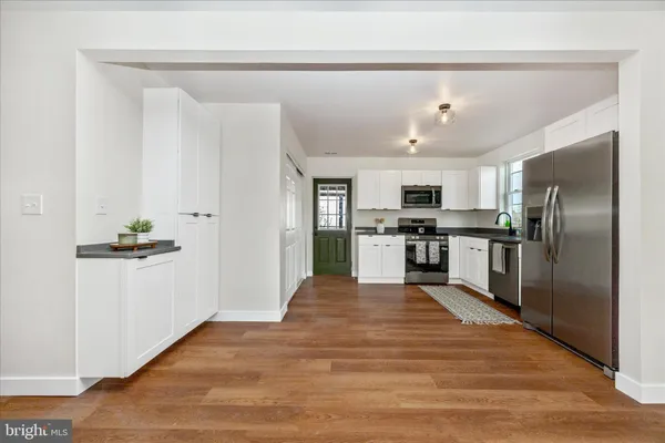 a kitchen with granite countertop a refrigerator and a stove top oven