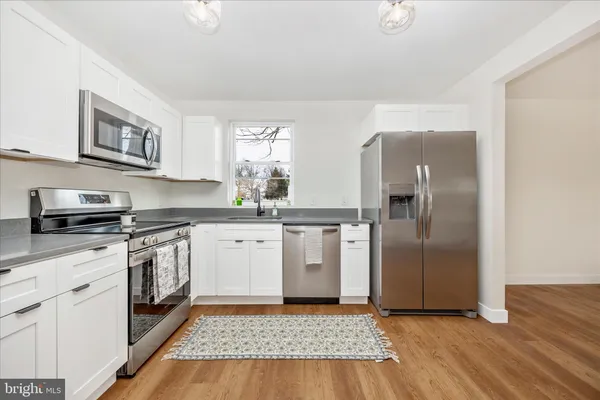 a kitchen with stainless steel appliances granite countertop a refrigerator and a stove top oven