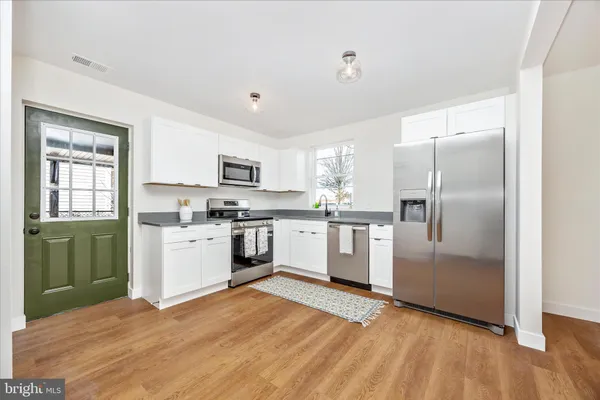 a kitchen with white cabinets and white appliances