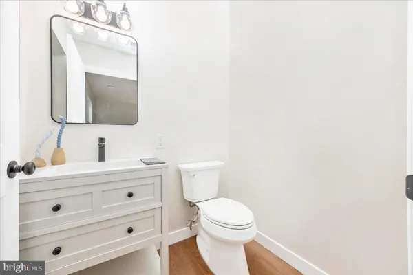 a bathroom with a toilet sink vanity and mirror