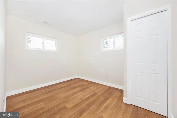a view of empty room with wooden floor